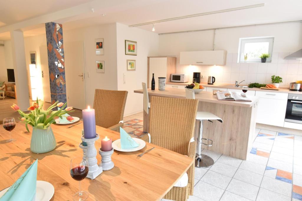 eine Küche und ein Esszimmer mit einem Holztisch mit Kerzen in der Unterkunft Stadtloft in Flensburg
