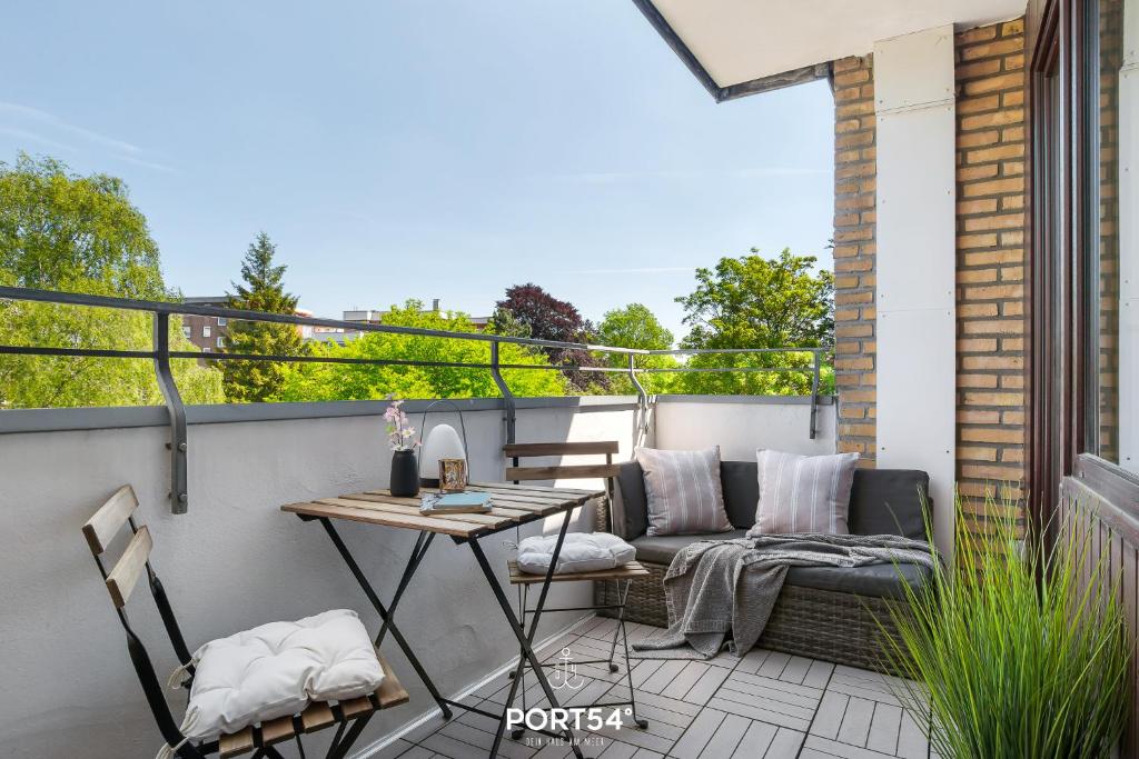 eine Terrasse mit einem Sofa und einem Tisch auf dem Balkon in der Unterkunft Jørgenshus in Flensburg