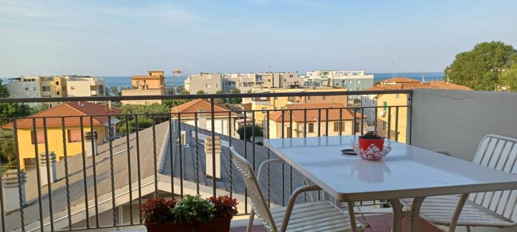 una mesa en un balcón con vistas a la ciudad en Appartamento Velvet Beach, en Senigallia