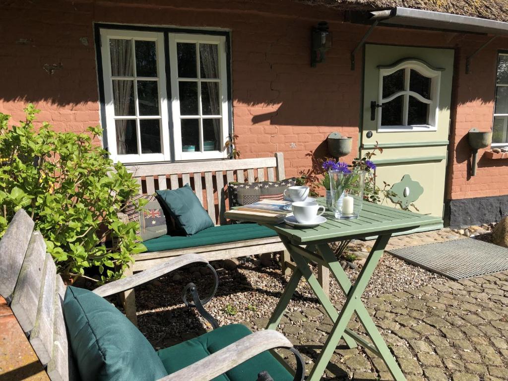 a table and bench in front of a house at Kate am Barkenhof in Ekenis