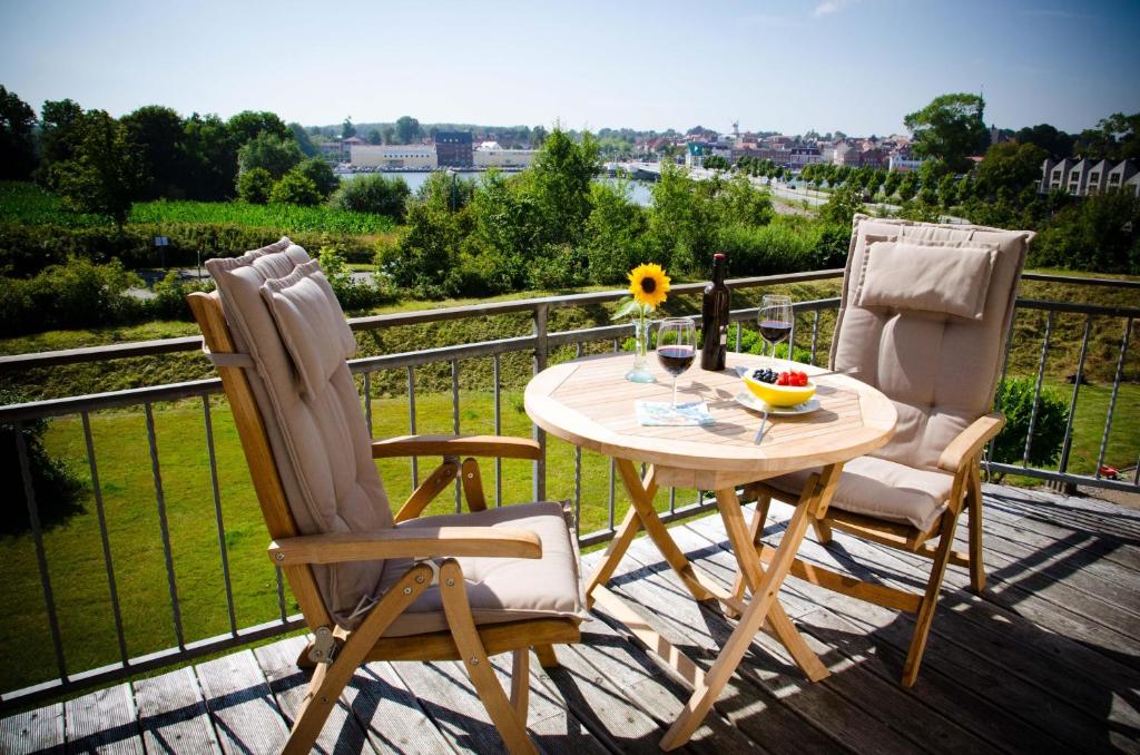 a table and two chairs on a deck with a view at Ferienhaus Kappelner Schleibrücke in Kappeln