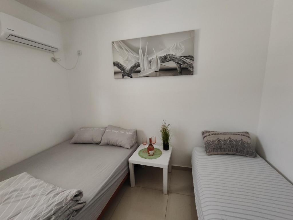 a bedroom with two beds and a small table at Apartment with terrace and parking in Eilat
