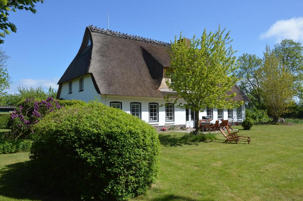 a white house with a gambrel roof at Hyggeby in Steinbergkirche