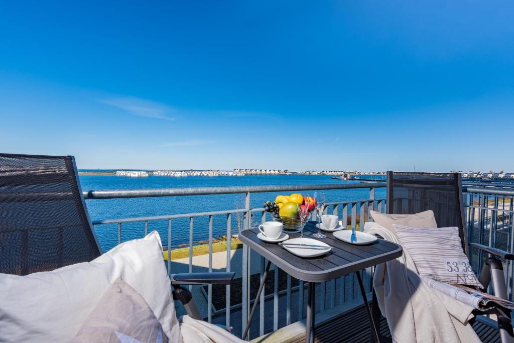a table on a balcony with a view of the water at Seestern in Olpenitz