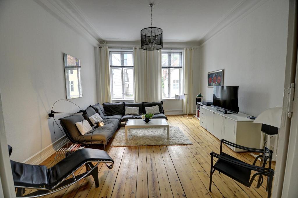 uma sala de estar com um sofá e uma televisão em Albatros em Flensburg
