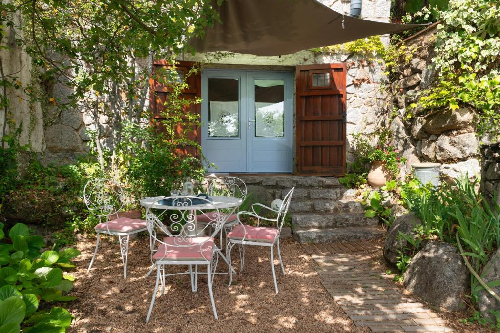 una mesa y sillas frente a una casa en Ca la Cèlia -Loft, en Maçanet de Cabrenys