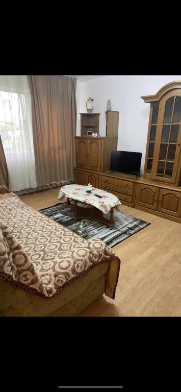 a bedroom with a bed and a table in it at Apartament parter in Craiova