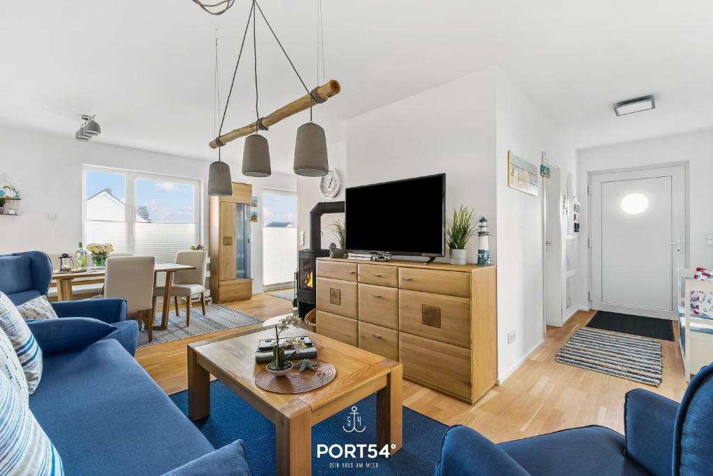 a living room with a blue couch and a tv at Captainslodge in Olpenitz