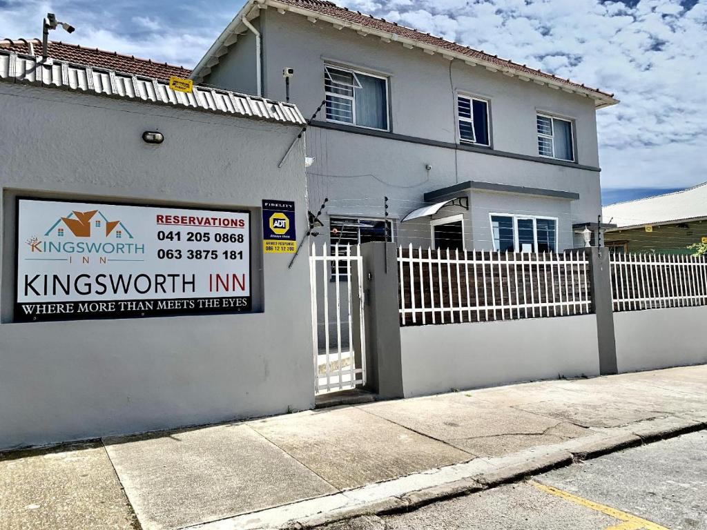 una casa blanca con un cartel delante en Kingsworth inn Port Elizabeth en Puerto Elizabeth