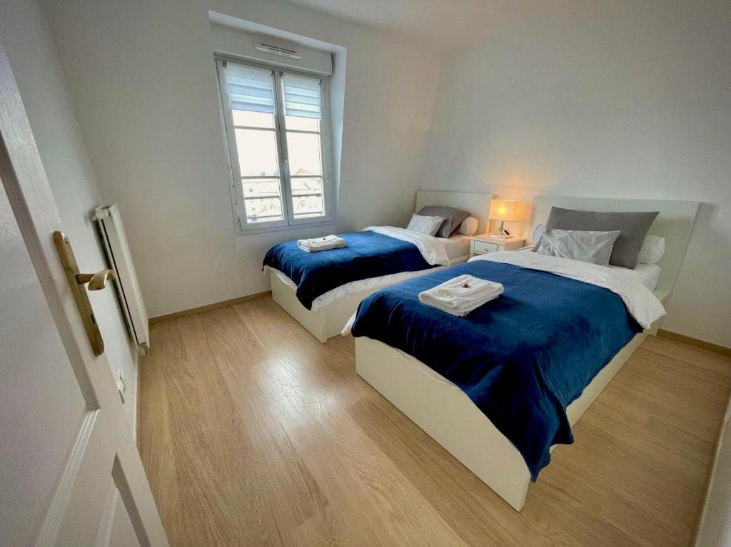 1 dormitorio con 2 camas y ventana en Family's Appartement Disney Paris , 2 Parking, en Serris