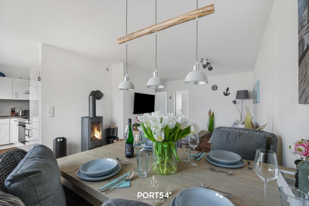 un tavolo da pranzo con un vaso di fiori sopra di Weisse Düne II a Olpenitz