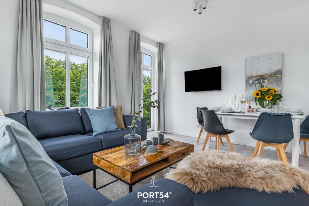 sala de estar con sofá azul y mesa en Ferienwohnung Hofwächter, App 13 Emmelsbüll en Emmelsbüll-Horsbüll