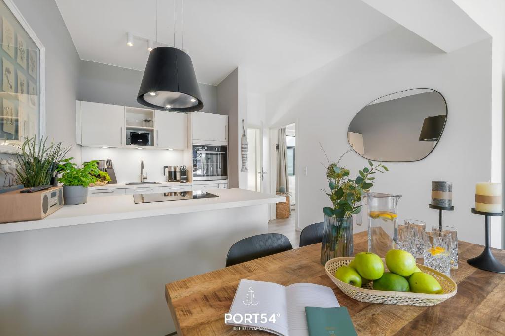 - une cuisine et un salon avec une table en bois et un bol de fruits dans l'établissement Ferienwohnung Freiherr, App 8 Emmelsbüll, à Emmelsbüll-Horsbüll