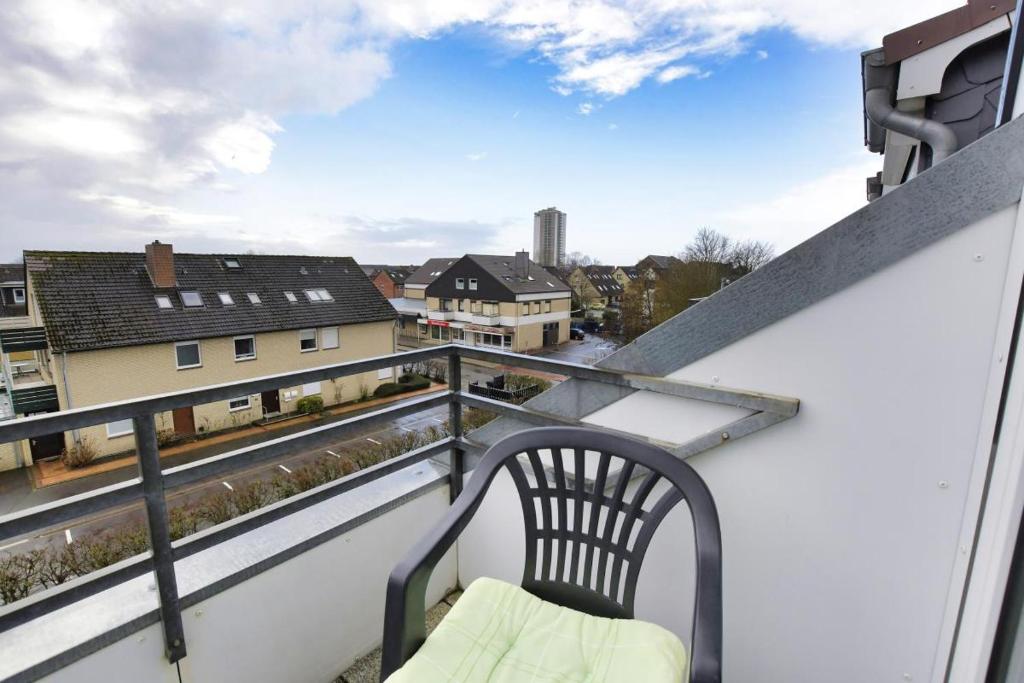 uma varanda com uma cadeira e vista para a cidade em Nordsee em Büsum