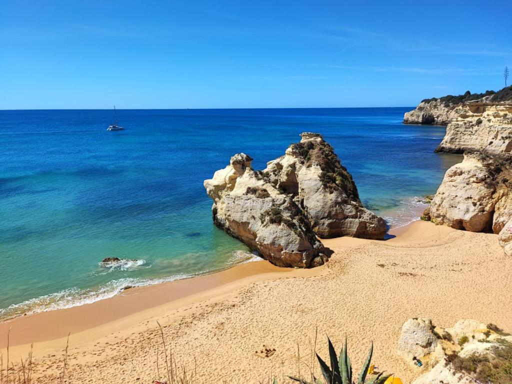a sandy beach with rocks in the ocean at Aldeamento Praia dos Beijinhos in Porches