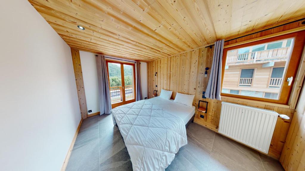 a small room with a bed and a window at Chalet Jogidi in Saint-Sorlin-dʼArves