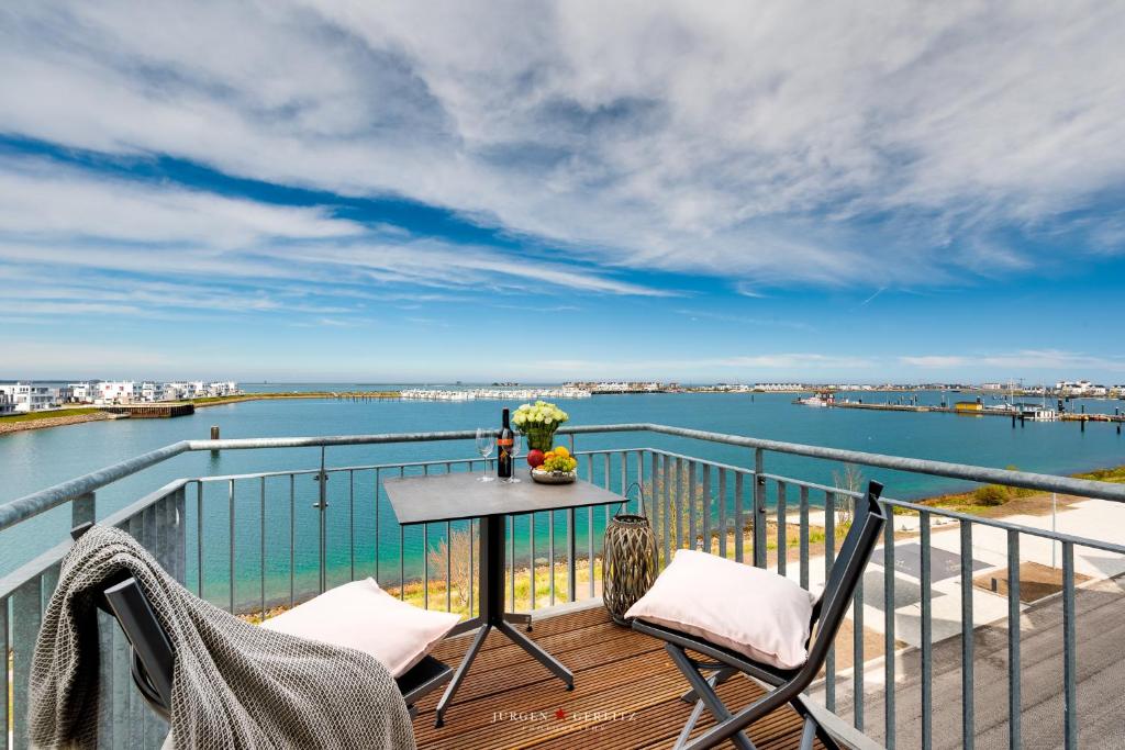 奧本尼茲的住宿－Sailors View，阳台配有桌椅,享有水景。