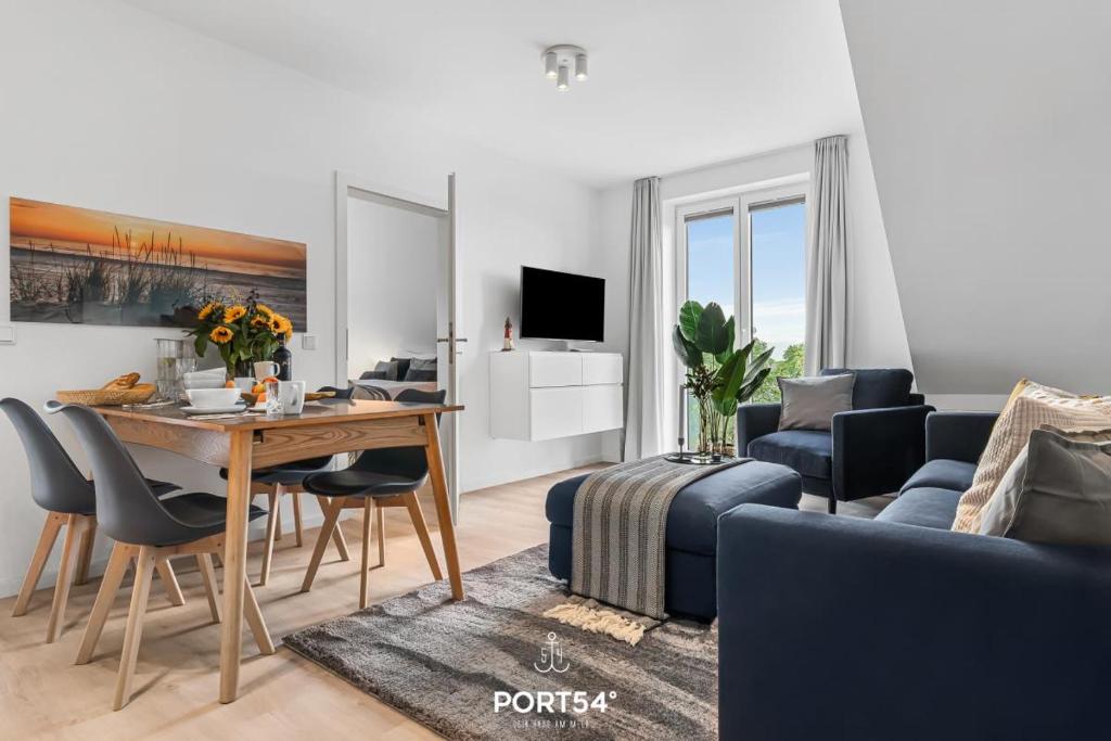 un salon avec une table et un canapé dans l'établissement Ferienwohnung Grüne Freiheit, App 14 Emmelsbüll, à Emmelsbüll-Horsbüll