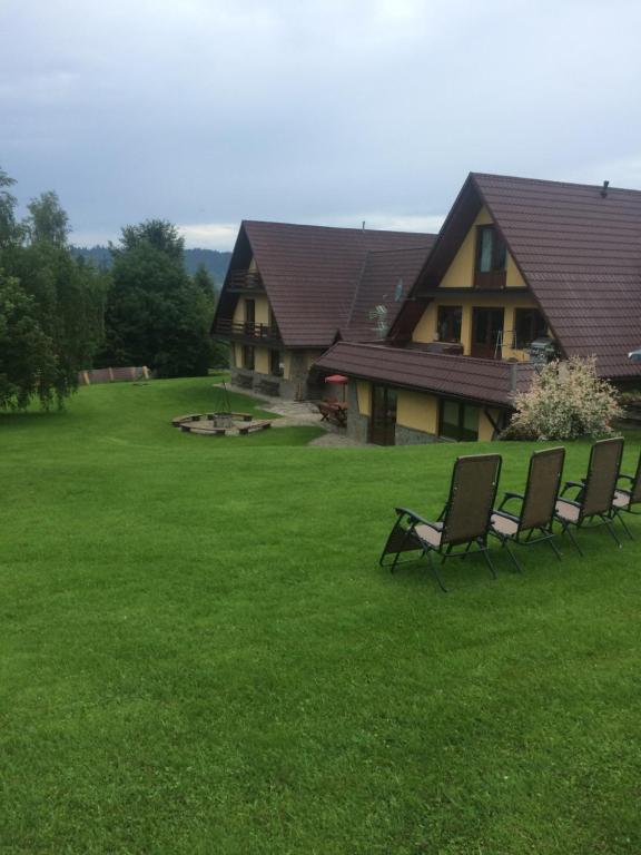 um grupo de cadeiras sentadas na relva em frente a uma casa em Słoneczny Apartament em Czarna Góra