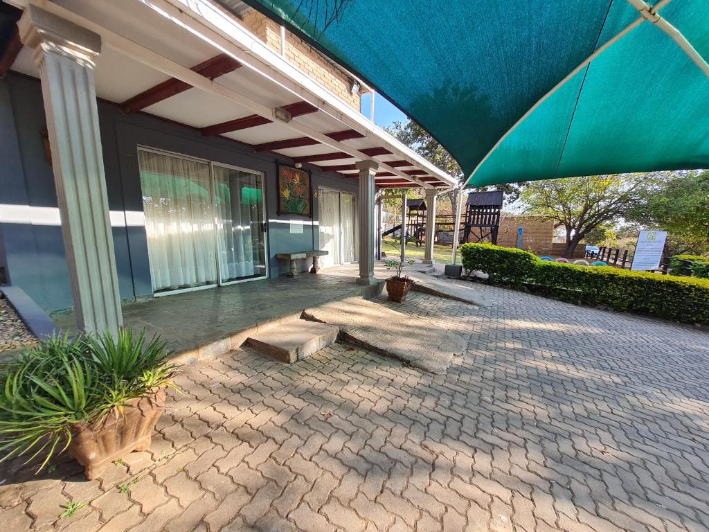 a patio with an umbrella on a building at N4 Guest Lodge in Rustenburg