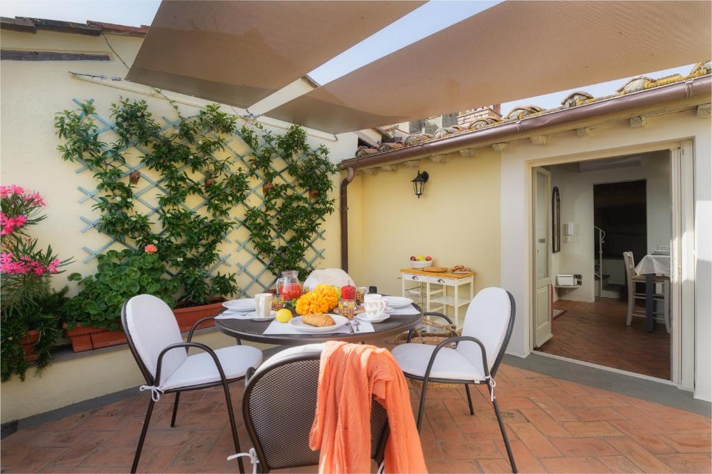 un patio con mesa y sillas en Terrazza Silena, centro storico con vista Cortona!, en Cortona