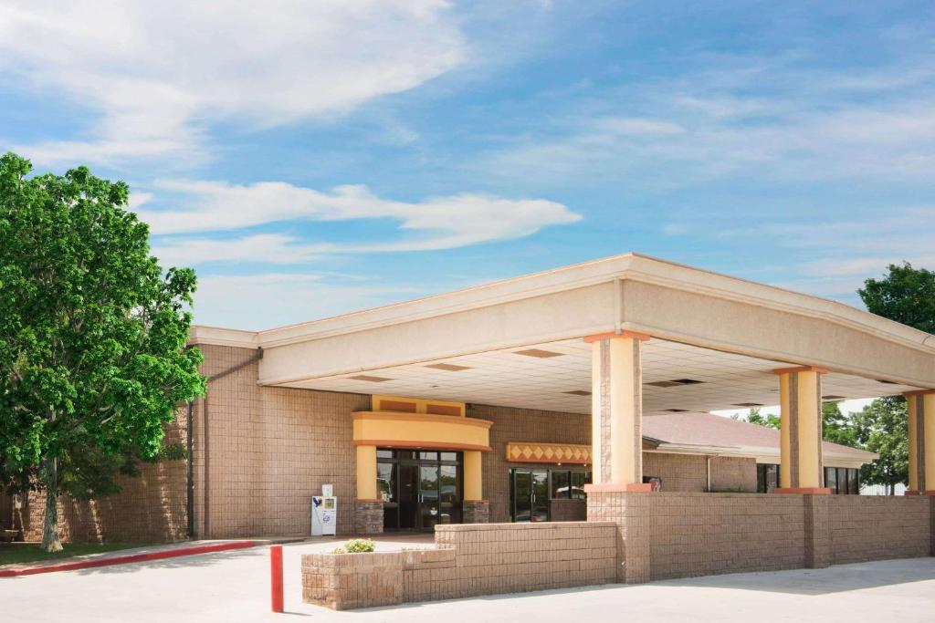 a gas station with a building at Travelodge by Wyndham Enid in Enid