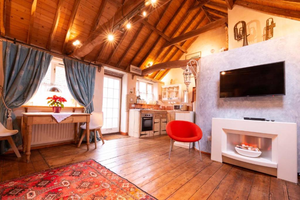 sala de estar con chimenea y silla roja en Snow Cottage laid back style with footpaths to a great Macro Brewery Pub 