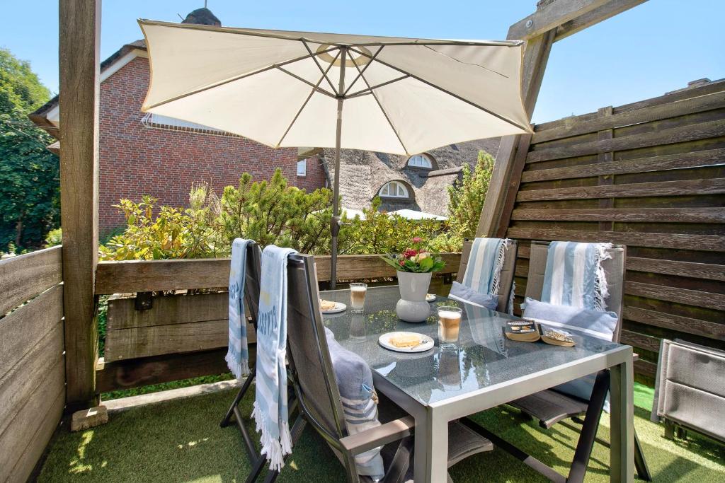 a table and chairs with an umbrella on a patio at Backbord 21 in Dangast