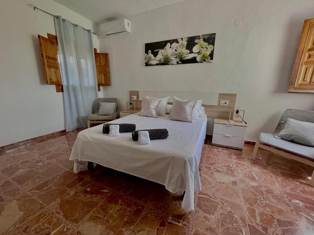 1 dormitorio con 1 cama blanca grande y 1 sofá en Casa de Huéspedes , Villa Adriana, en Jávea