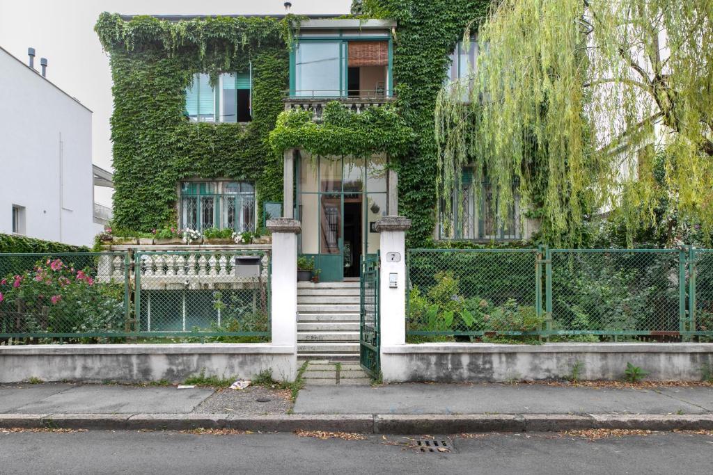 una casa con una porta bianca e edera di Casa Flores - 2 camere Padova a Padova