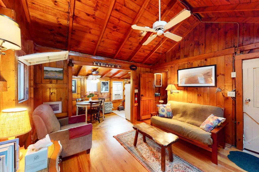 ein Wohnzimmer mit Holzwänden und einer Decke in der Unterkunft Drummers Cove Gem in Wellfleet