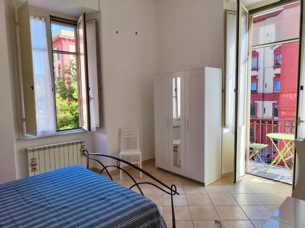 een slaapkamer met een bed in een kamer met ramen bij Luminhouse Napoli in Napels