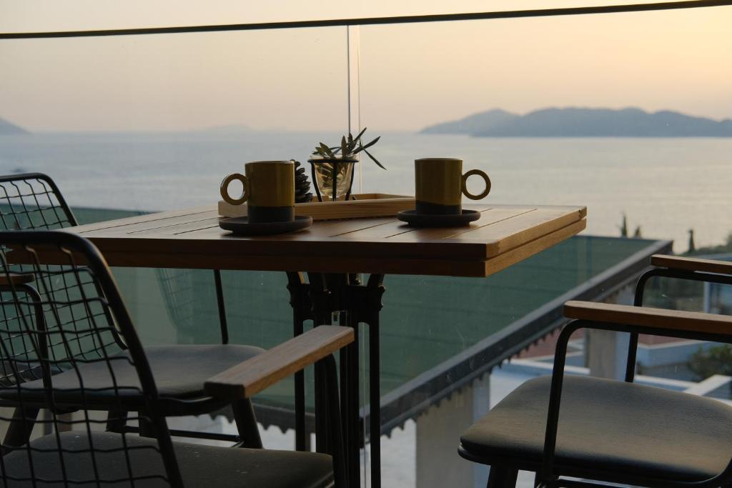 a table with two coffee cups and chairs on a balcony at Kaktus Suites in Kas