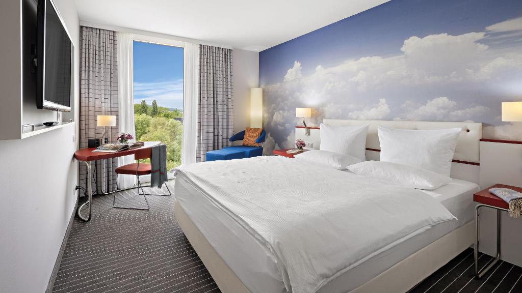 1 dormitorio con cama blanca y pared azul en Hey Lou Hotel Friedrichshafen, en Friedrichshafen