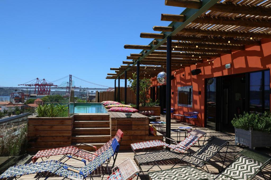 eine Terrasse mit Stühlen und einem Pool auf einem Gebäude in der Unterkunft JAM Lisbon in Lissabon