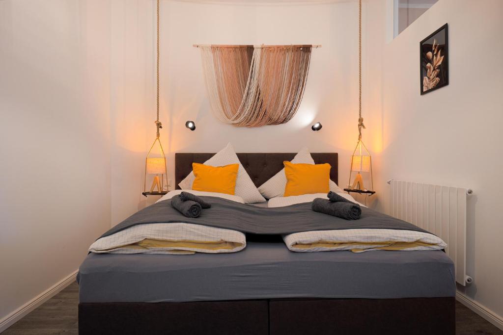 a bedroom with a large bed with orange pillows at Blue Chili 32 - Stadtwohnung für 3 modern zentral Karlshorst Wlan in Berlin