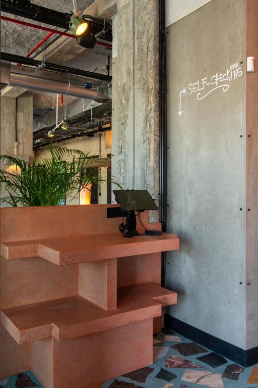 A built-in communal work counter with a laptop and industrial interior details.