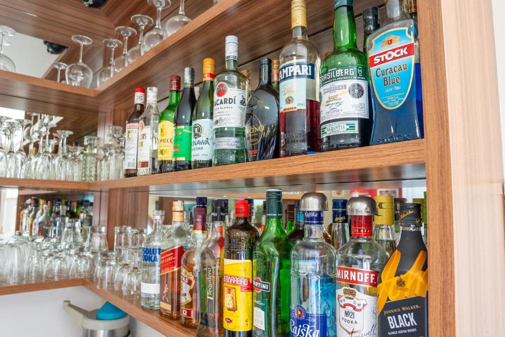 a shelf filled with lots of bottles of alcohol at Hotel Raul's in Gaspar