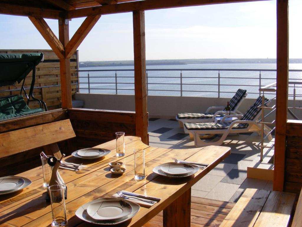 une table avec des assiettes et des ustensiles au-dessus d'une terrasse dans l'établissement Elena's Terrace, à Mamaia