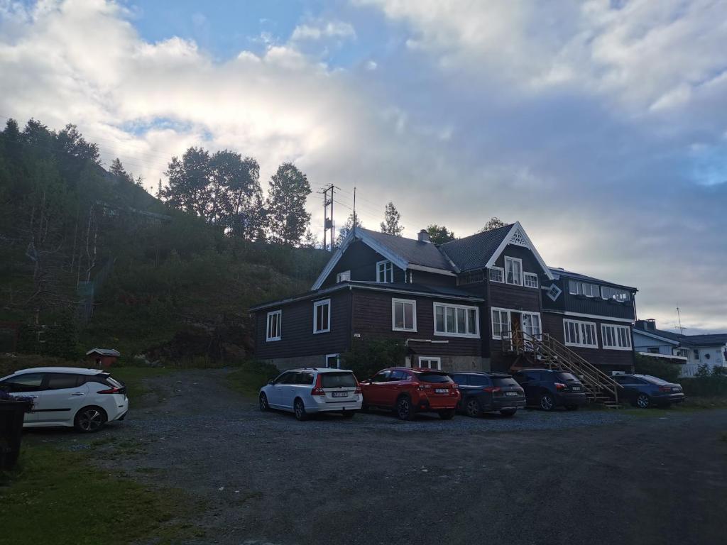 uma casa grande com carros estacionados em frente em Eikre Fjellgård em Hemsedal