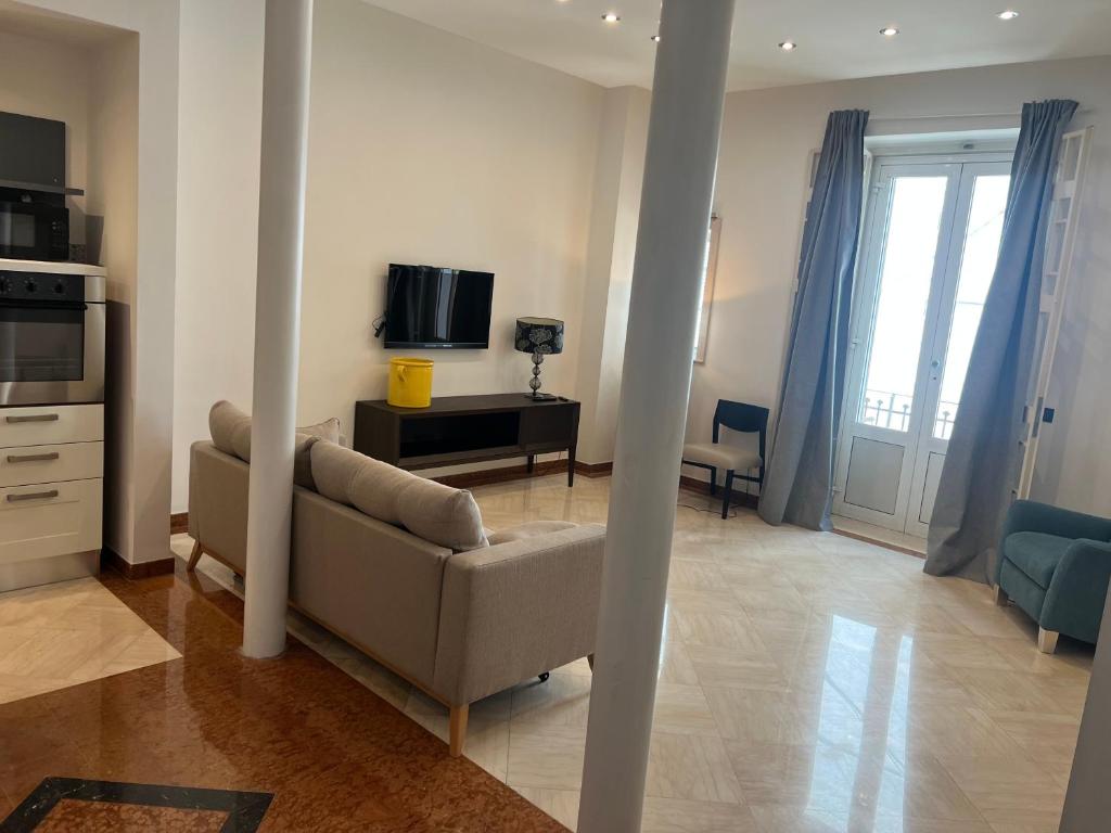 uma sala de estar com um sofá e uma televisão em Putignani Exclusive Suite em Bari