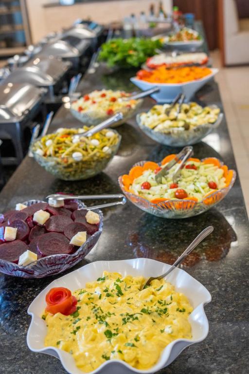 a buffet line with bowls of different types of food at Hotel Raul's in Gaspar