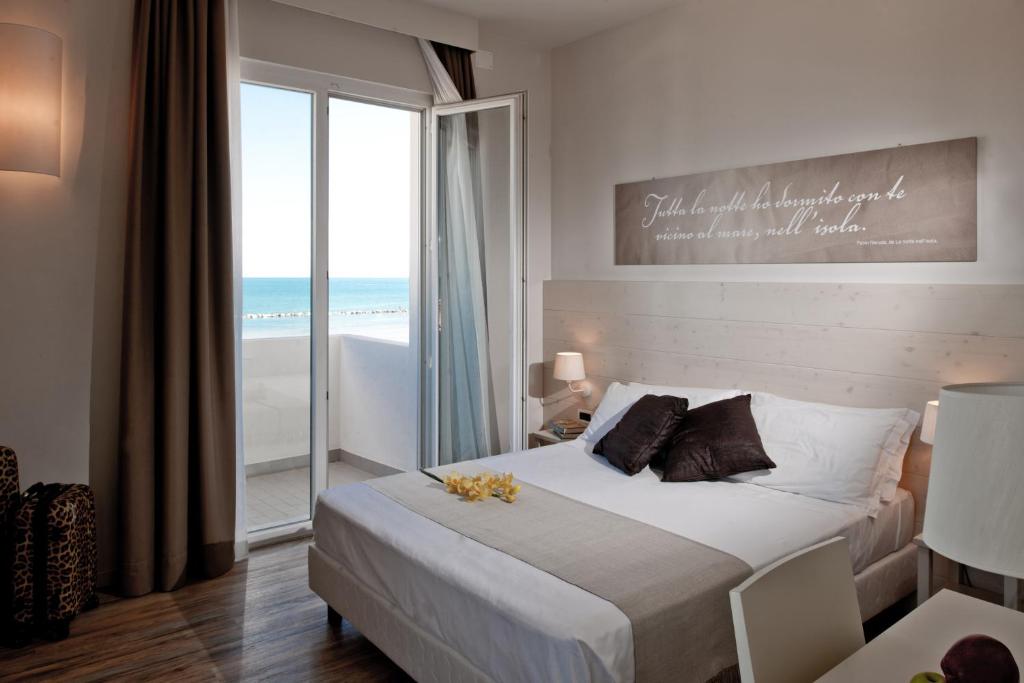 a bedroom with a bed with a view of the ocean at Hotel Universal in Senigallia