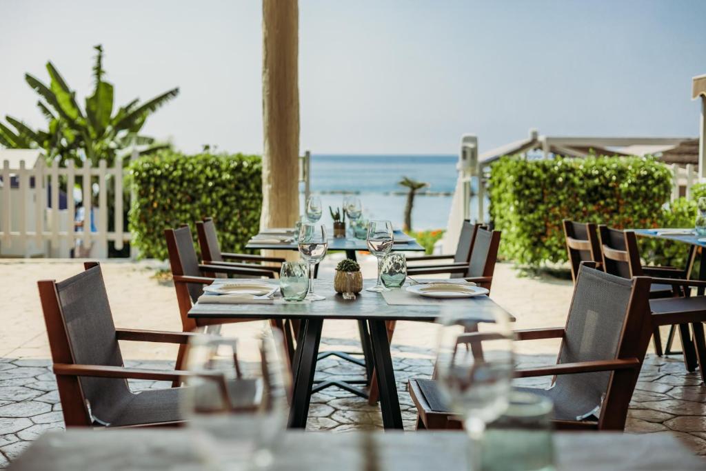 a table with glasses on it next to the beach at Atlantica Bay - Adults Only in Limassol