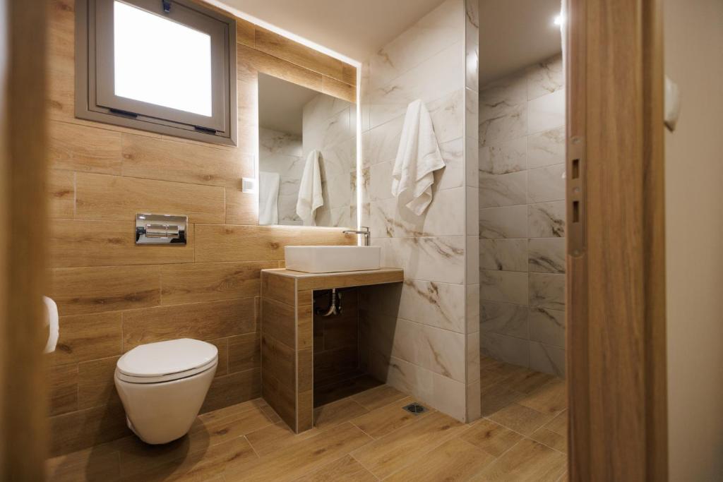 a bathroom with a toilet and a sink at La villa events in Amalias