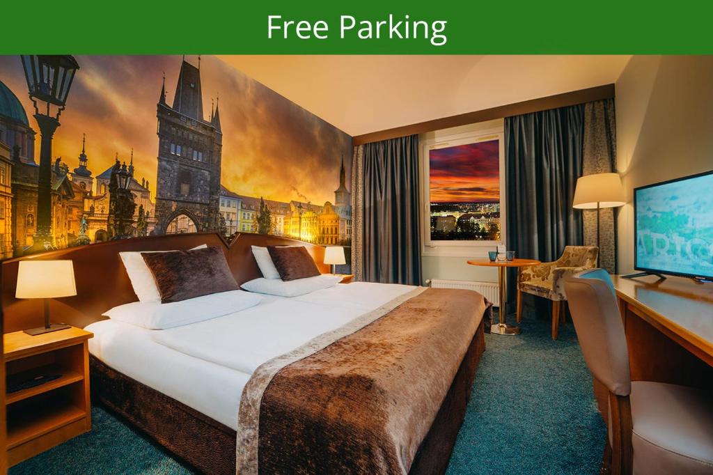 um quarto de hotel com uma cama grande e uma secretária em Plaza Prague Hotel - Czech Leading Hotels em Praga