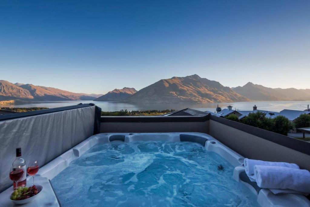 a hot tub on a rooftop with a view of the mountains at Queenstown Grandview with Spa Pool in Queenstown