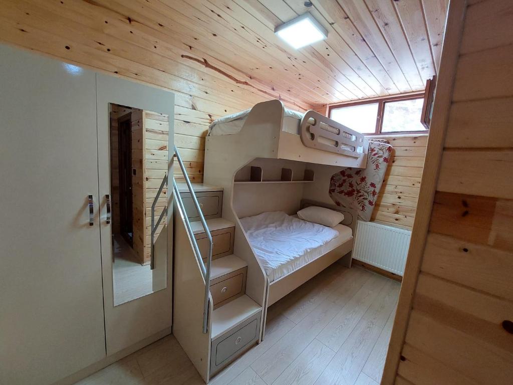 ウズンギョルにあるEŞ Pansiyonの二段ベッドと階段が備わる小さな客室です。