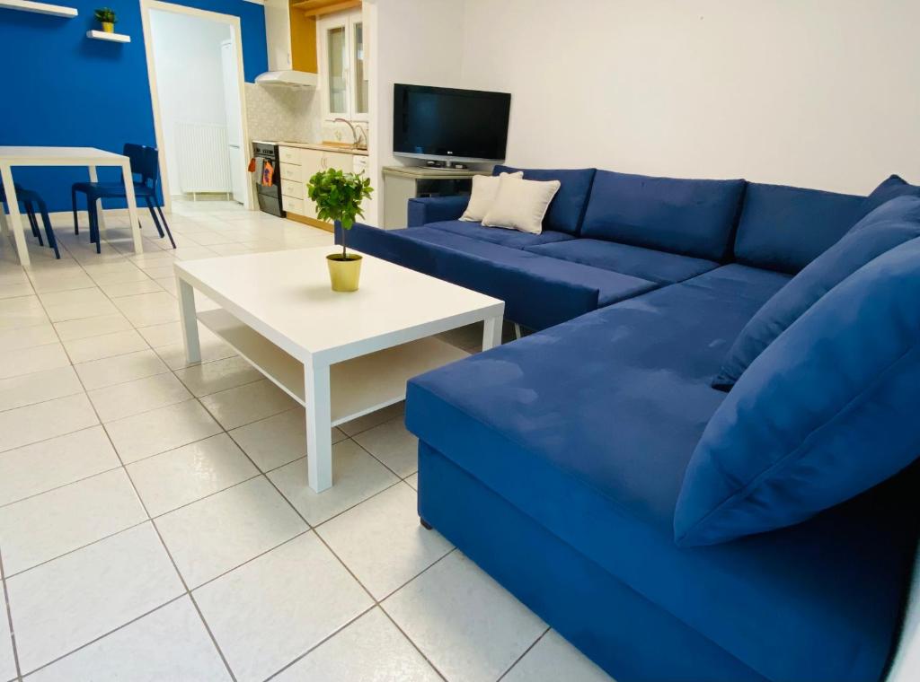 Koker's Place في سلانيك: غرفة معيشة مع أريكة زرقاء وطاولة