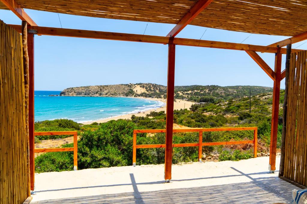 a view of the beach from the porch of a house at Exoristoi Nature Suites in Gavdos